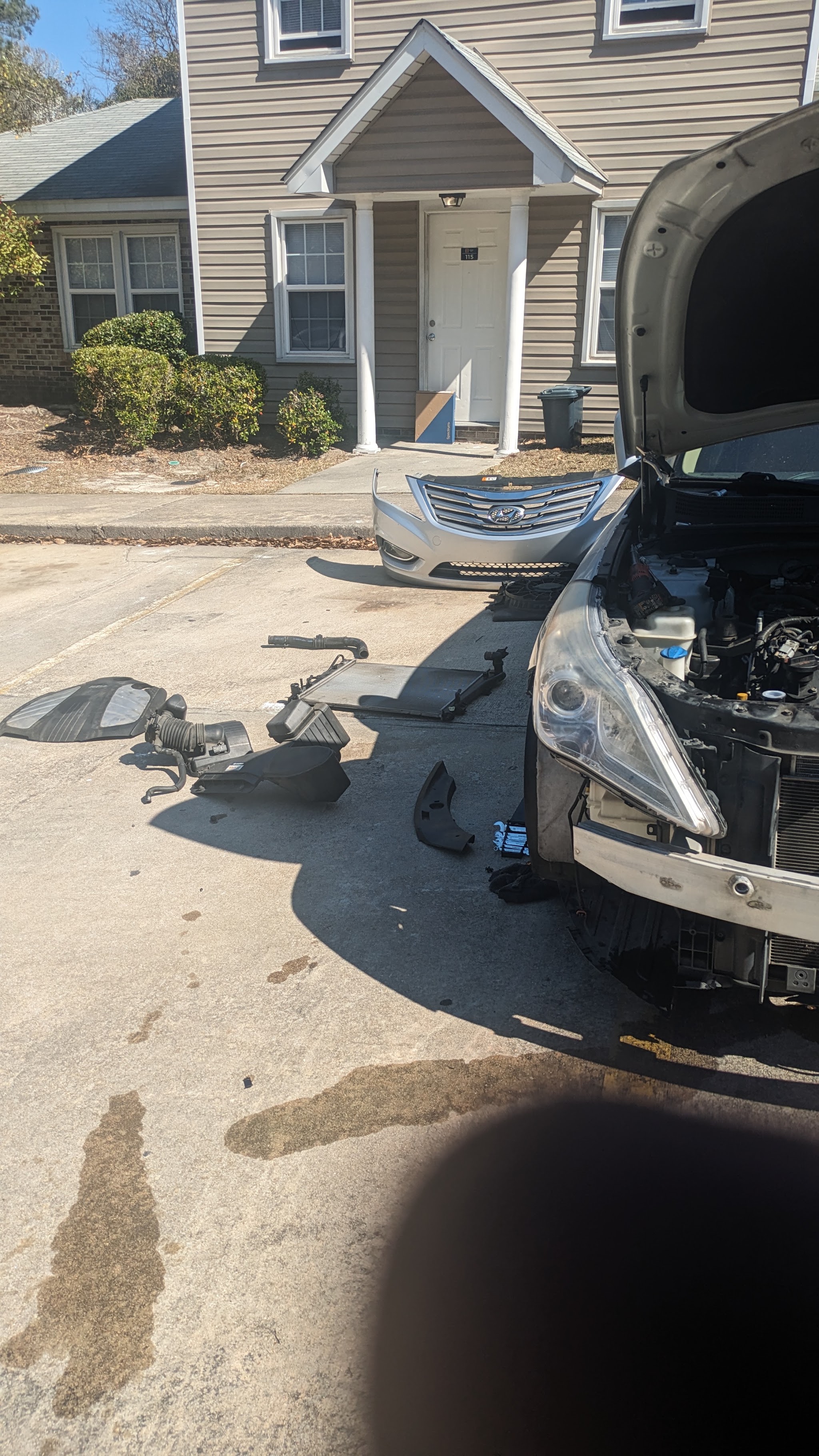 Radiator and front end parts laid out during a repair in a parking lot