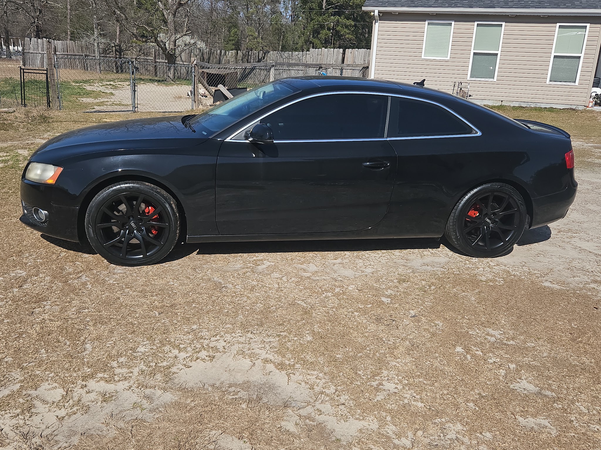 Black Audi coupe with black wheels and red calipers after the job