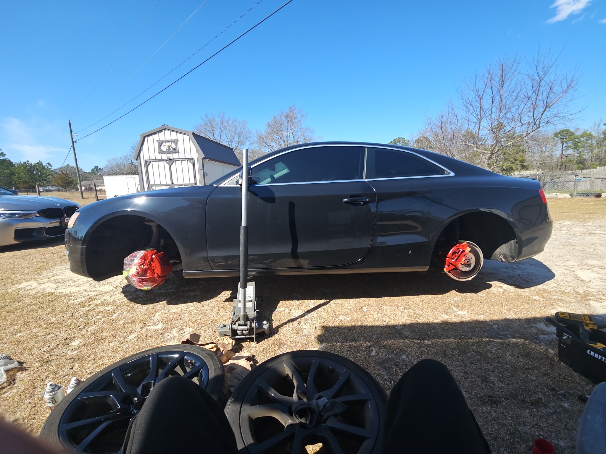 Brake job on a black Audi coupe, front wheels off and calipers painted red